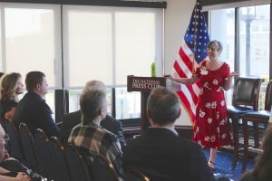 Speaker at "National Press Club" podium and talking to audience members