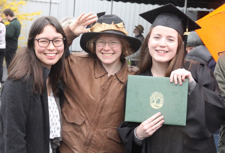 graduating students holding up their diplomas