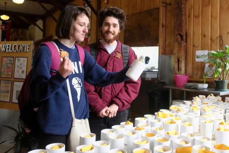 Students holding a mug and smiling