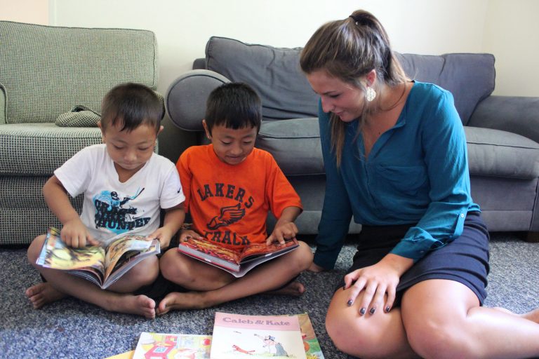 Parent sitting with children and coloring books