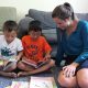 Parent sitting with children and coloring books