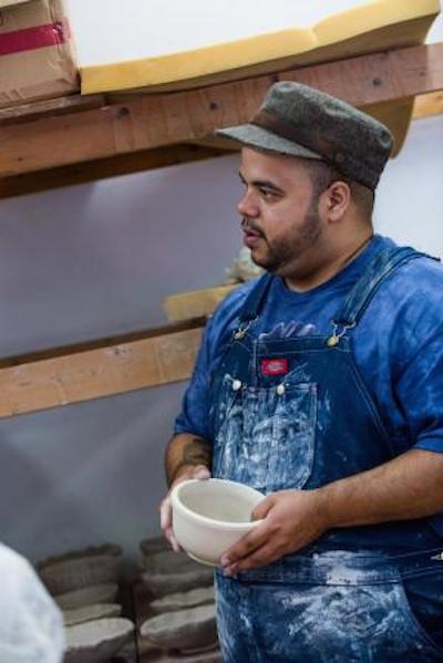 Roberto Lugo holding a ceramic bowl