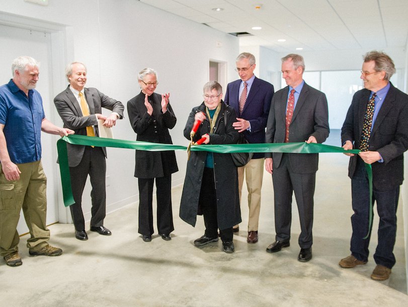 (pictured right, at center, joined by Dan Cotter, director of plant and operations, former chair Dean Nicyper ’76, former president Ellen McCulloch-Lovell, President Kevin Quigley, and visual arts faculty member Tim Segar) all are clapping while one cuts a green ribbon