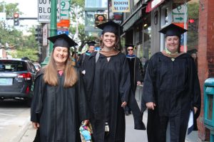 Students walking while wearing their graduation cap and gowns