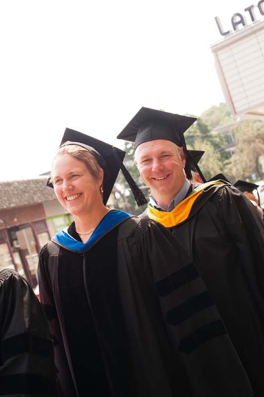 Two people wearing graduation cap and gown