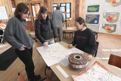 professor looks at cartography projects with students.