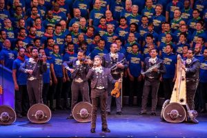 Allen Magaña singing in front of an orchestra/band