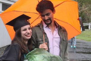 A graduate and a well-wisher under an umbrella