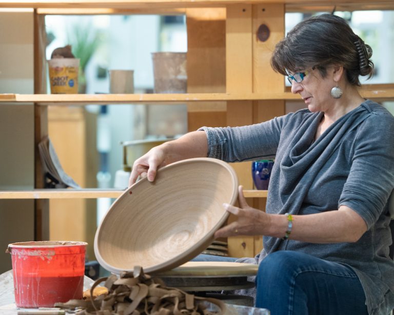 Teta holding an unglazed bowl