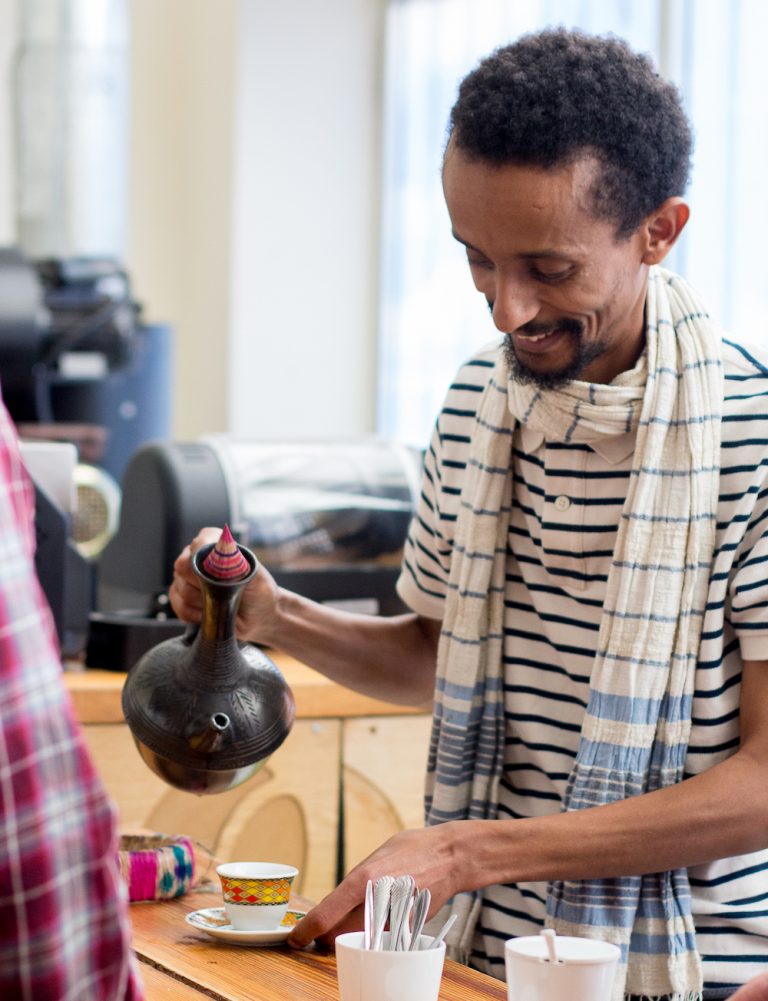 Dagmawi Iyasu pouring a cup a coffee