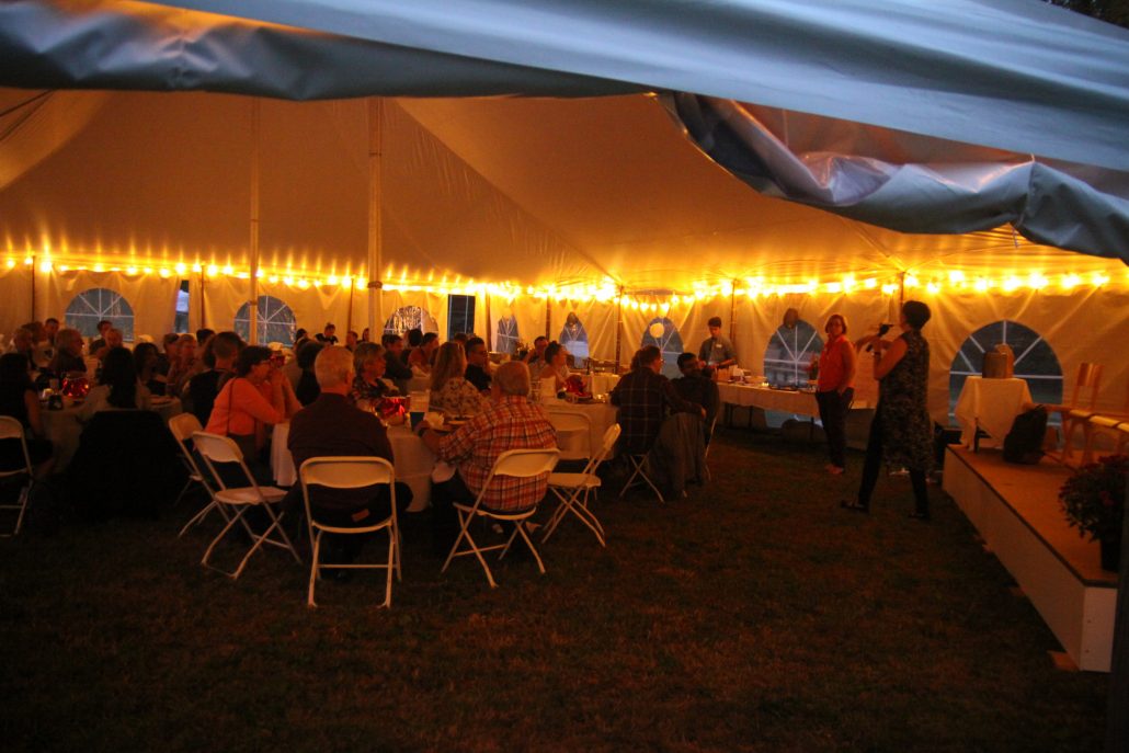 Marlboro Alumni seated under a tent at night