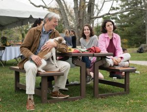 students sitting around picnic table holding a dog